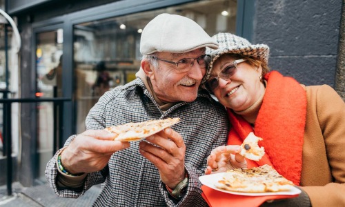 a couple eating pizza