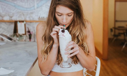 a woman drinking a milkshake